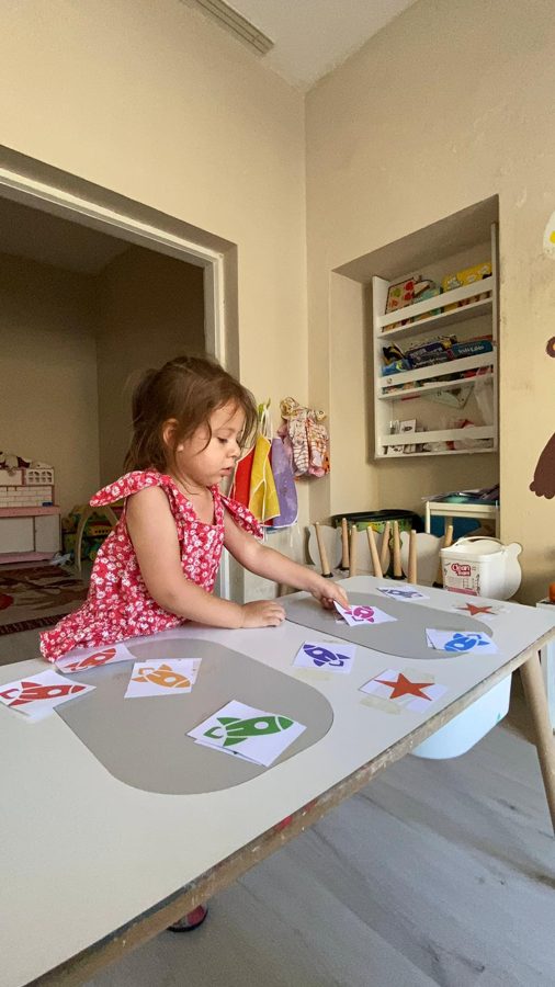 Çocuk, masaya dizilmiş renkli roket ve yıldız kartlarını eşleştiriyor